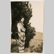 Tomoye (Nozawa) Takahashi in kimono standing by tree (ddr-densho-426-2148)