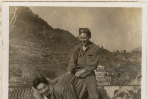 Two men pretending to be a horse with a third riding them (ddr-densho-466-359)