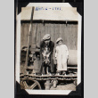 Two boys and a dog stand atop a piece of equipment (ddr-densho-404-38)
