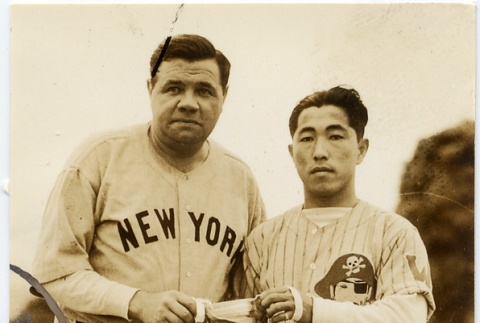 Babe Ruth holding a trophy with a player from the Waiakea Pirates (ddr-njpa-1-1380)
