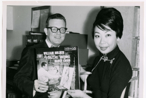 Mary Mon Toy with man holding album soundtrack for The World of Suzie Wong film (ddr-densho-367-188)