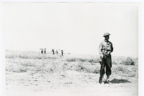 One soldier, marchers in background (ddr-densho-1007-417)