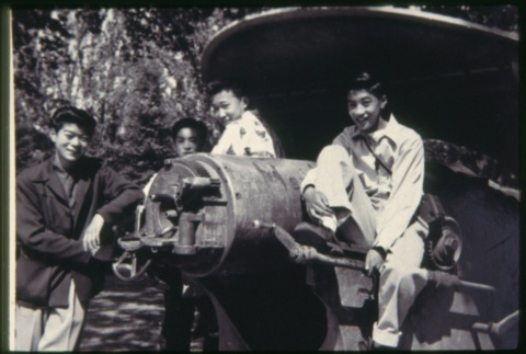 Group of young men sitting on field gun (ddr-densho-330-221)