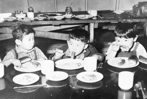 Three children in a camp dining hall (ddr-densho-37-10)