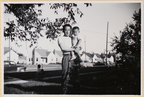 Man holding child in yard (ddr-densho-522-73)