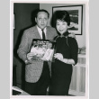 Mary Mon Toy with man holding album soundtrack for The World of Suzie Wong film (ddr-densho-367-190)