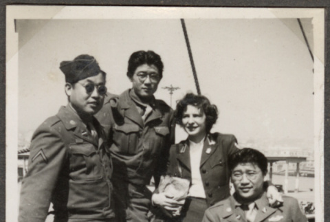 Three men in uniform standing with woman (ddr-densho-466-110)