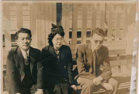 Tomoye (Nozawa) Takahashi seated on bench with two men (ddr-densho-426-1482)