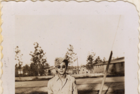 Man in sunglasses in field outside barracks (ddr-densho-466-231)