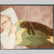 Chester Sakura lying down with cat (ddr-densho-523-643)