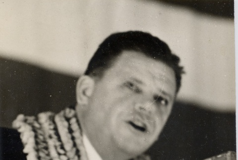 A man wearing leis giving a speech (ddr-njpa-1-1251)