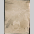Man and child sitting on beach (ddr-densho-523-106)