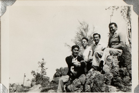 Four men sitting on rocks (ddr-densho-587-35)