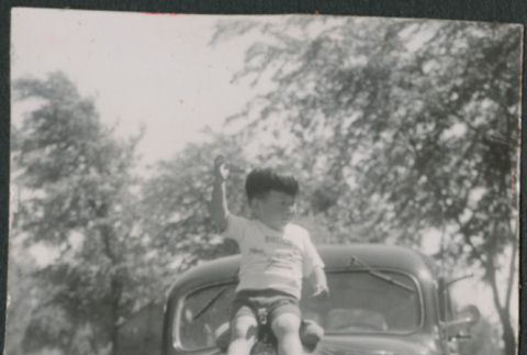 Boy sitting on hood of car (ddr-densho-523-212)