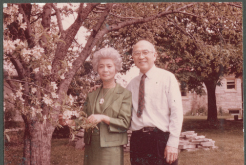Chester and Agnes Sakura by flowering tree (ddr-densho-523-534)