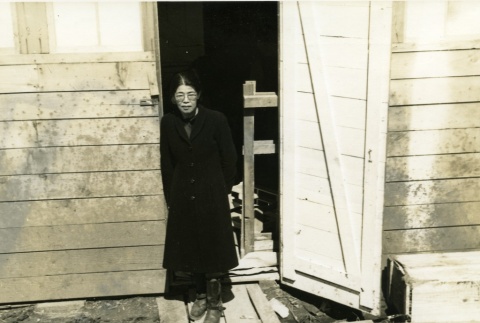 Woman standing in a barracks doorway at Tanforan Assembly Center (ddr-densho-22-444)