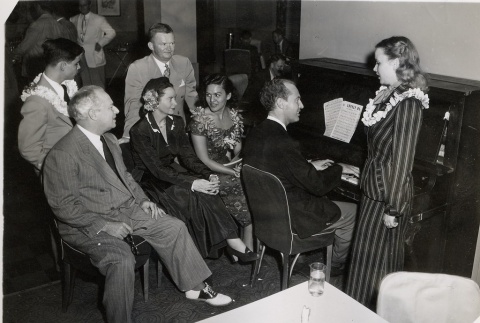 Miss Hawaii and others watching a young woman singing with piano (ddr-njpa-2-842)