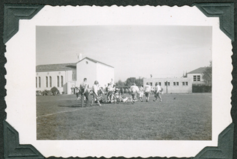 Men playing football on field (ddr-densho-475-705)