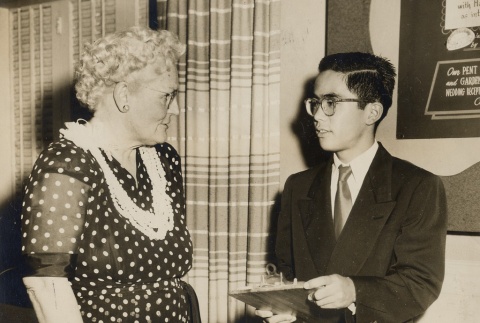 Woman speaking to young man holding clipboard (ddr-njpa-2-1165)