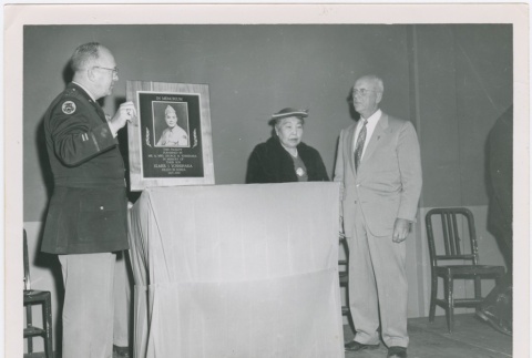 (Photograph) - Image of men and woman with memorial plaque (ddr-densho-332-32-mezzanine-b4c3dd21b3)