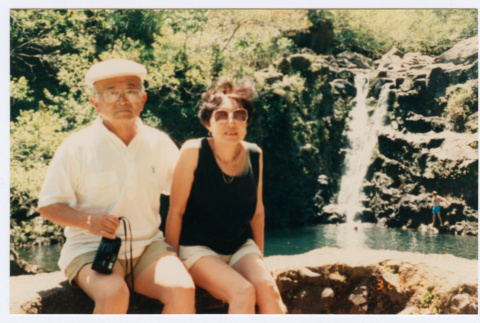 Bill and Tomi Iino sitting in front of waterfall (ddr-densho-368-291)