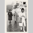Masako Takahashi with two women walking in rain (ddr-densho-426-230)
