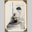 Man using equipment at a pharmacy counter (ddr-densho-542-503)