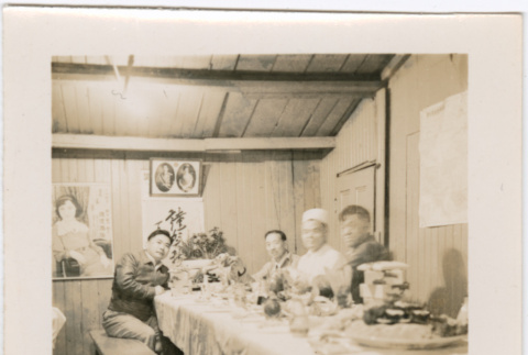 Four men sitting at a table with plates of food (ddr-densho-426-1935)