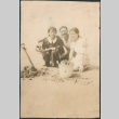 Two women, a man and dog with bucket of razor clams (ddr-densho-523-45)