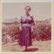 Woman standing by hedge (ddr-densho-522-47)