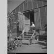 Man sitting in barracks entrance (ddr-densho-153-321)