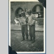 Soldiers reading a newspaper on V-J Day (ddr-densho-22-75)