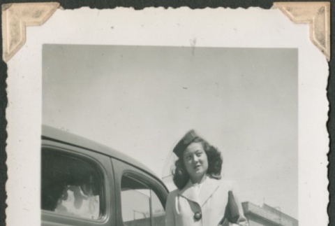 Woman posing near a car (ddr-densho-321-174)