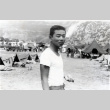 Hisashi Nakashima standing with army camp in background (ddr-densho-474-231)