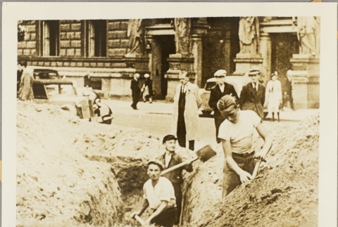 Men digging a trench next to a city street (ddr-njpa-13-1048)
