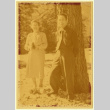 Man and woman posing with a pine tree (ddr-densho-542-3)