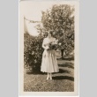 Woman in yard holding a bouquet (ddr-densho-313-39)