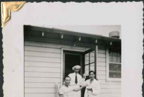 Three men on steps of building, William Tsuchida on left (ddr-densho-434-221)