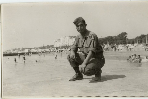 Japanese American soldier crouched on a beach (ddr-densho-201-205)