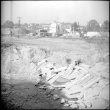 Dirt road with broken concrete and building in background (ddr-densho-377-1509)