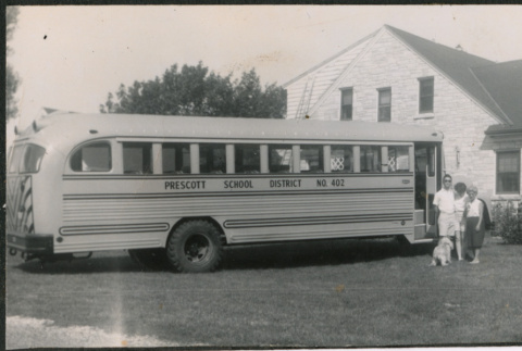 Three people standing next to school bus (ddr-densho-523-349)