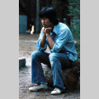 Glen Yamamoto sitting on a stump (ddr-densho-336-408)
