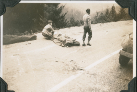 Two men on road with bodies covered in blankets (ddr-ajah-2-213)