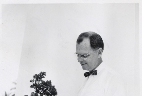 Man holding a bonsai (ddr-njpa-2-613)