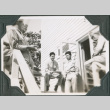 Group of men sitting on railing outside building (ddr-ajah-2-399)