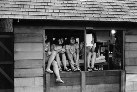Campers sitting in a cabin window (ddr-densho-336-141)