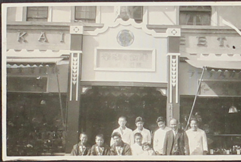 A group posing in front of a business (ddr-densho-278-54)