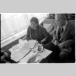 Loni Ding, Barry Saiki and one other looking through clippings (ddr-densho-1007-1171)