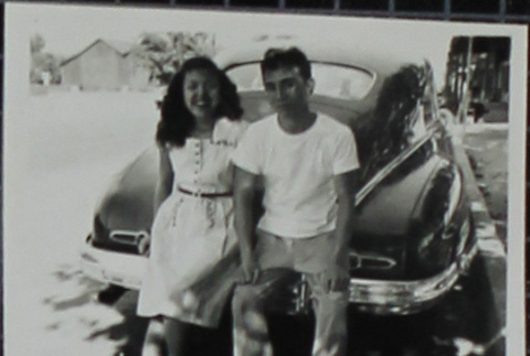A woman and man leaning on a car (ddr-densho-321-1233)