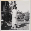 Woman standing by tree outside house (ddr-densho-522-14)